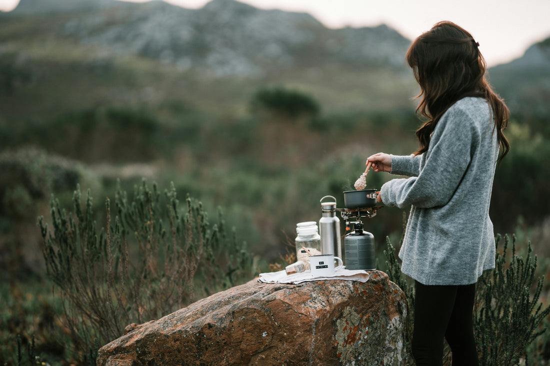 Woman making hot drink in countryside