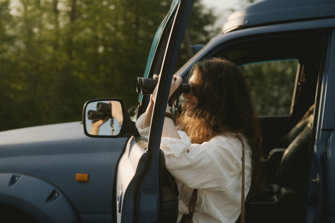 Young birdwatcher next to car