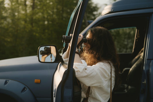 Young birdwatcher next to car