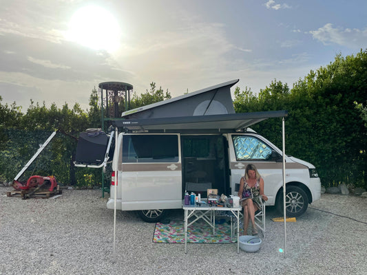 Woman reading outside campervan