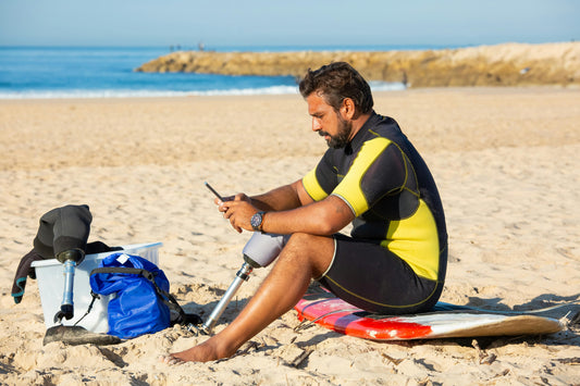 Surfer using his phone on beach
