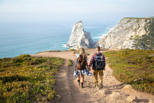 Man and woman hiking along cliffs